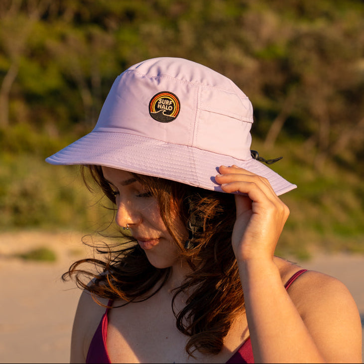 Woman wearing a Lilac surf bucket hat with wide hard brim on the beach