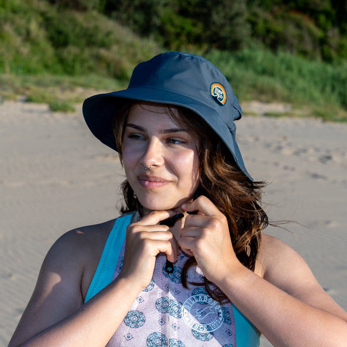 women adjusting her surf hat grey at the beach