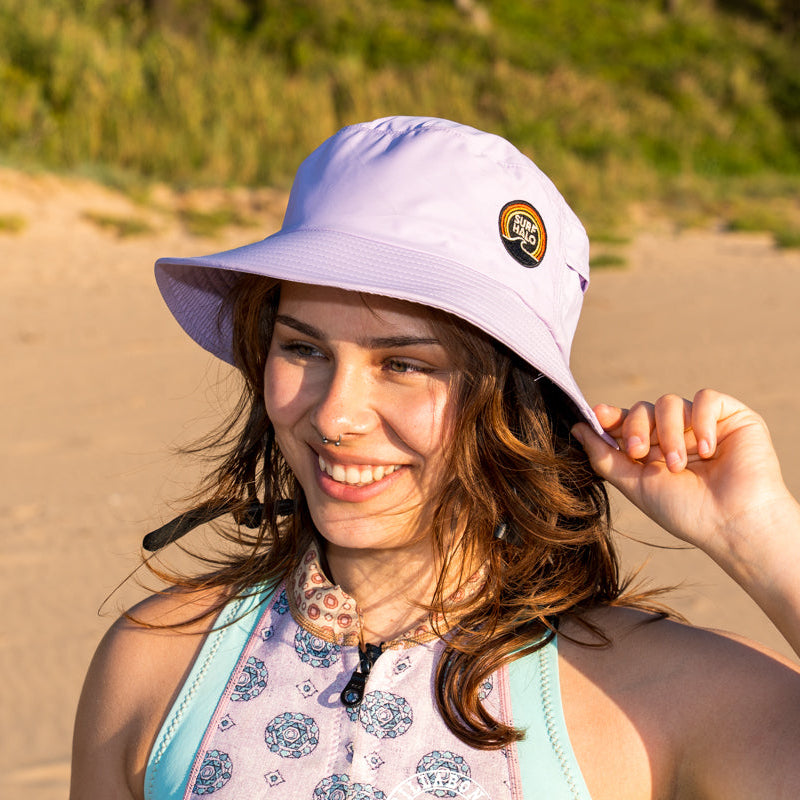 women wearing a surf hat wide brim in the sand surfer
