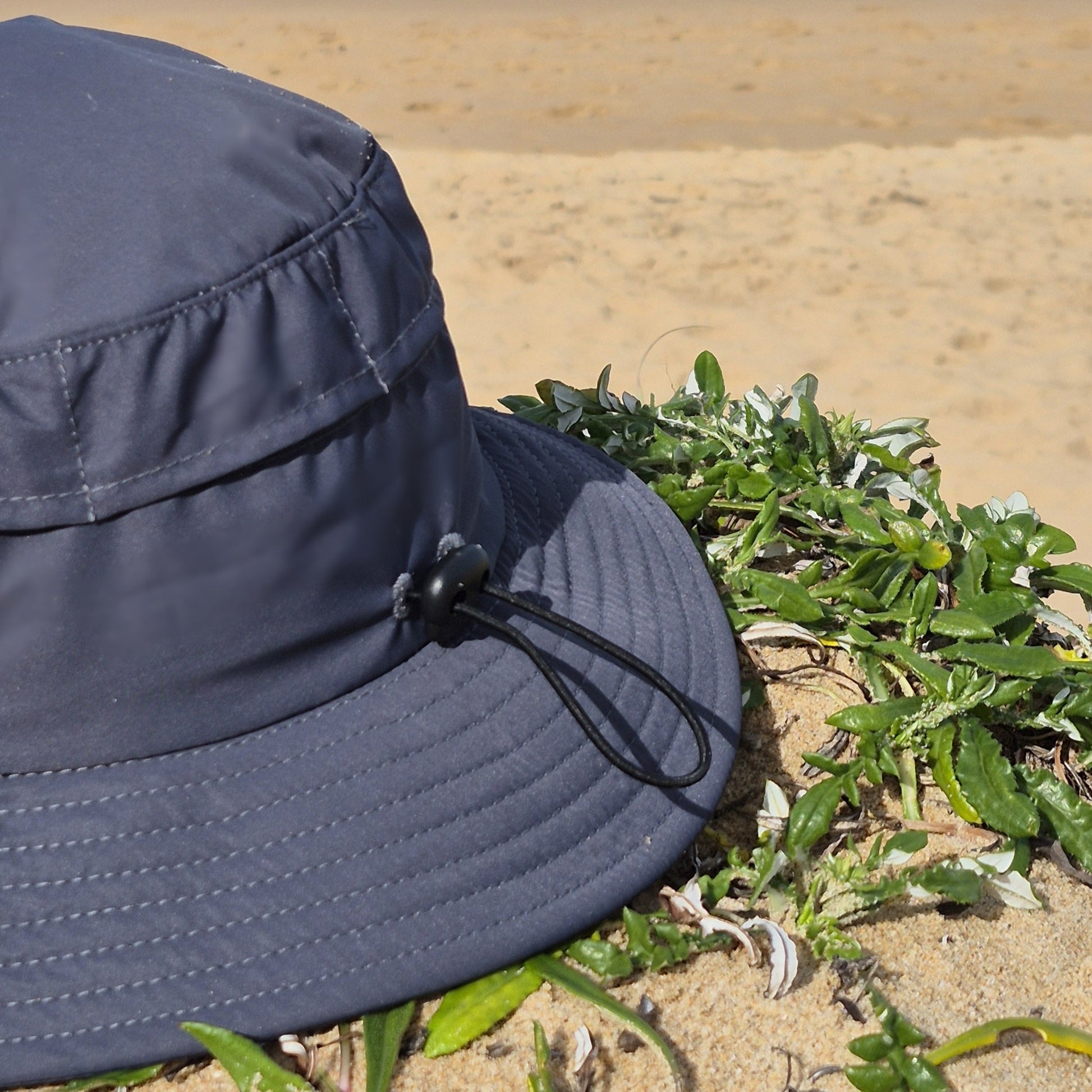 Surf hat helmet charcoal grey back view, elastic adjustable strap and mesh panels for optimal waterflow