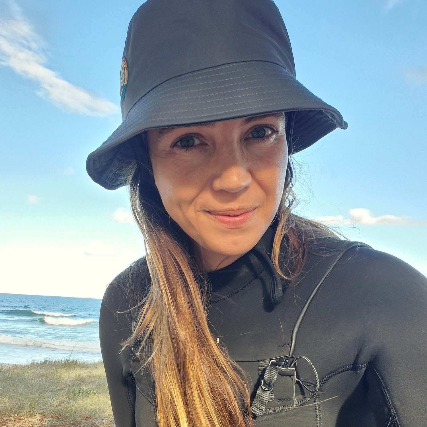 women wearing helmet surf hat and black wetsuit 